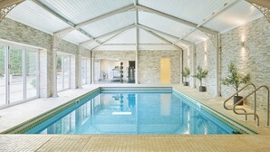 Ein Hallenbad mit hoher Decke und Steinwänden.