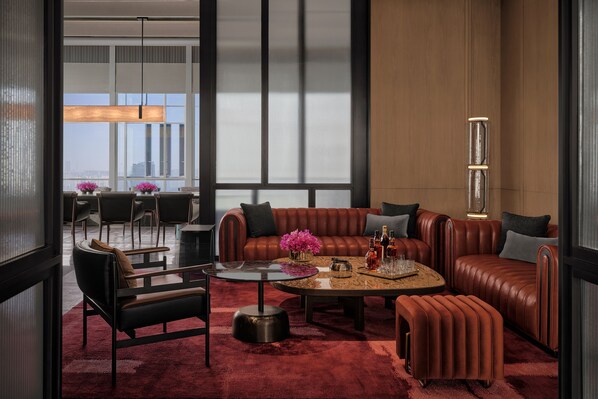 A modern living room with a leather sofa, a round coffee table, and a red carpet. - ANDAZ NANJING HEXI, BY HYATT (Nanjing)