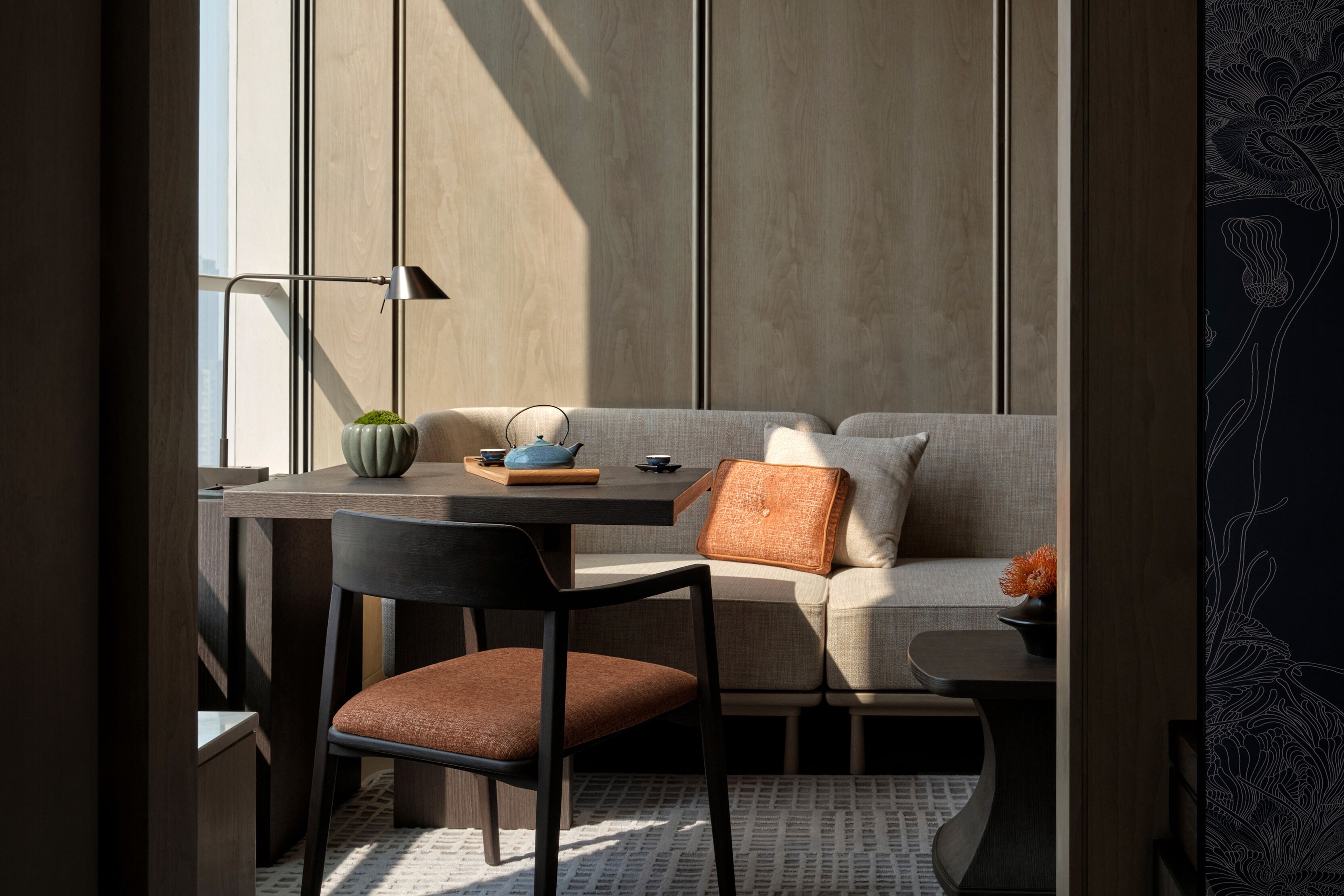 A modern interior with a dining area, sofa, and a decorative wall.