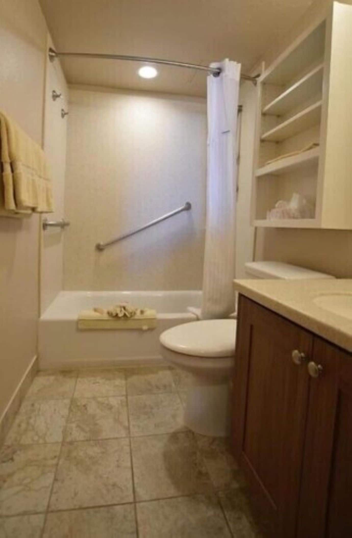 A bathroom with a bathtub, toilet, and a shower area.