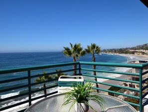A balcony with a view of the ocean, palm trees, and a beach. - Laguna Surf (Laguna Beach)