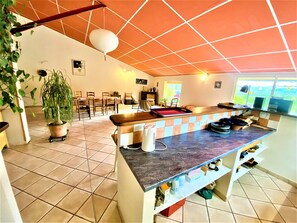 Una cocina con piso de baldosas, encimera de madera y una ventana.