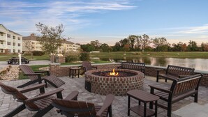 A fire pit surrounded by Adirondack chairs and picnic tables, overlooking a lake and a golf course. - 2BD/Williamsburg at Governor's Green - Lots to do! (Williamsburg)