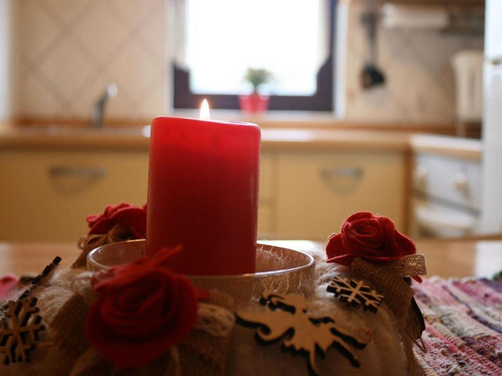 Une bougie posée sur une table agrémentée d’une décoration rustique.