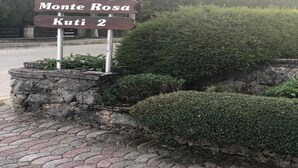 Un panneau de signalisation indiquant les directions vers les lieux suivants : « Apartmani », « Monte Rosa » et « Kuti 2 ».