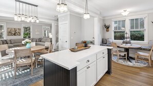 A spacious kitchen with a large island, pendant lighting, and a view of the outdoors. - Seabrook Along for the Ride | Hot Tub, Dog Friendly, Carriage House, Sleeps 14 (Pacific Beach)