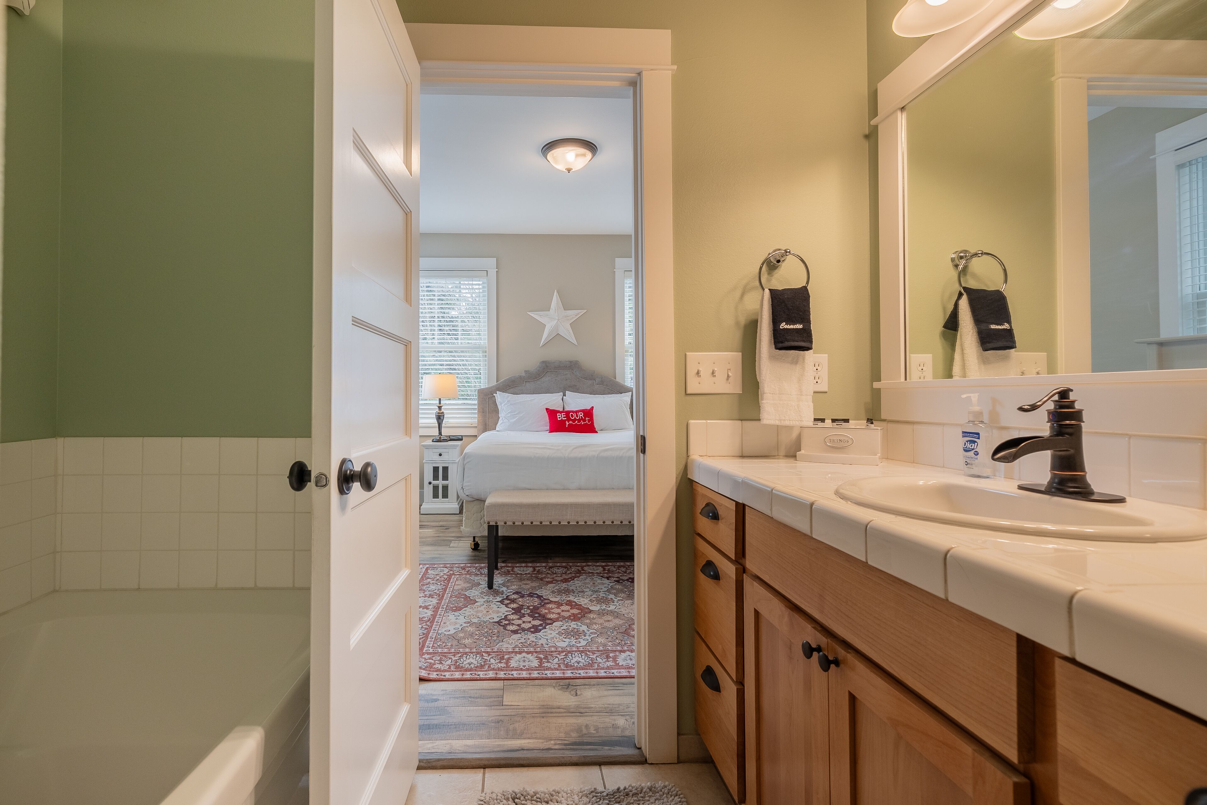 Une salle de bain avec un lavabo blanc, un miroir et un espace douche.