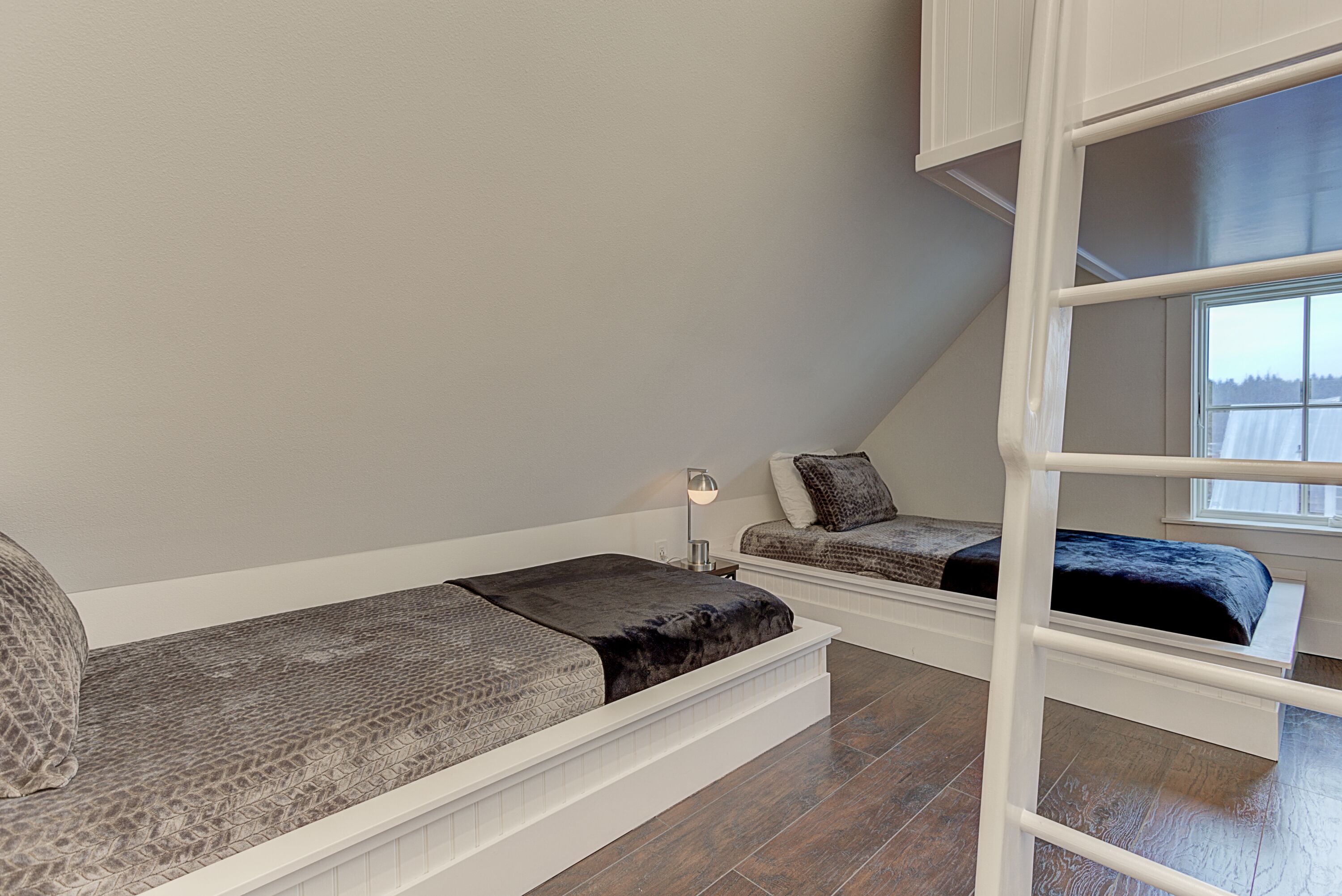 Ett sovrum på entresolplan med en våningssäng och en bäddsoffa.