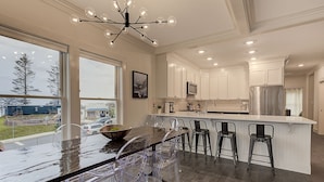 A modern kitchen with a large island, bar stools, and a view of the outside. - Seabrook Beach Baller | Town Center, Dog Friendly, 3BR, Sleeps 8, Fireplace (Pacific Beach)