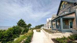 Une propriété située sur la côte, avec un chemin de gravier menant à une maison dotée d’un porche.