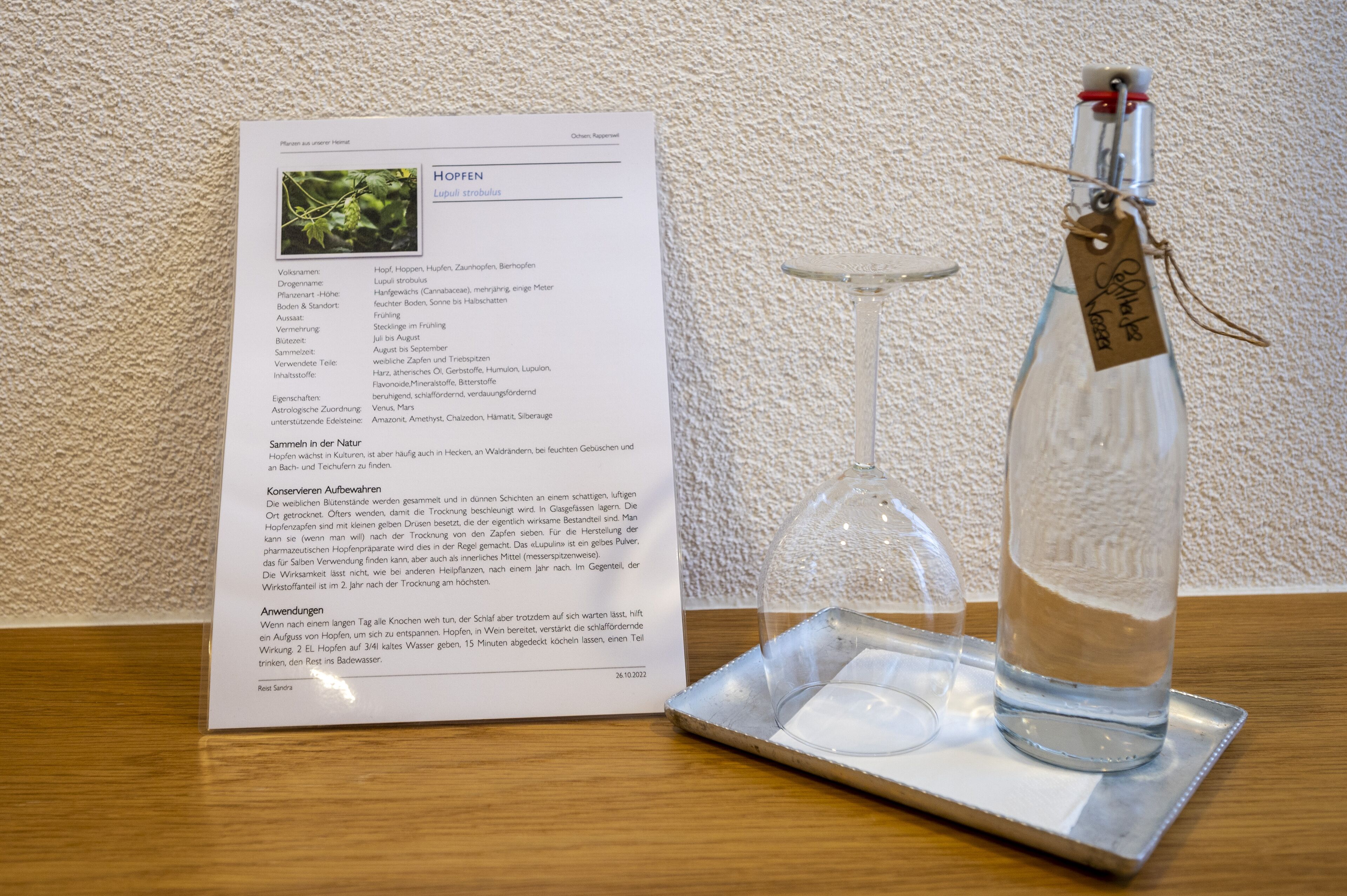 A menu with a glass bottle and a wine glass on a tray.