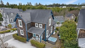 Une maison à deux étages dotée d’un porche couvert, d’un jacuzzi et d’une cour clôturée.