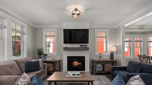 A living room with a fireplace, sofas, and a television. - *NEW* Coastal Oasis, Hot Tub! (Pacific Beach)