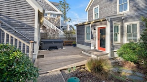 A wooden deck with a hot tub, a red door, and a small garden area. - Seabrook Crew Rest | Ping Pong, Carriage House 4BR | Sleeps 12, Crescent Park (Pacific Beach)