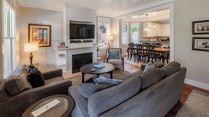 Un salon avec une cheminée, un canapé et un coin repas.