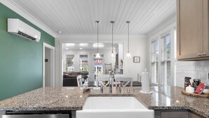 A modern kitchen with granite countertops, stainless steel appliances, and pendant lighting.