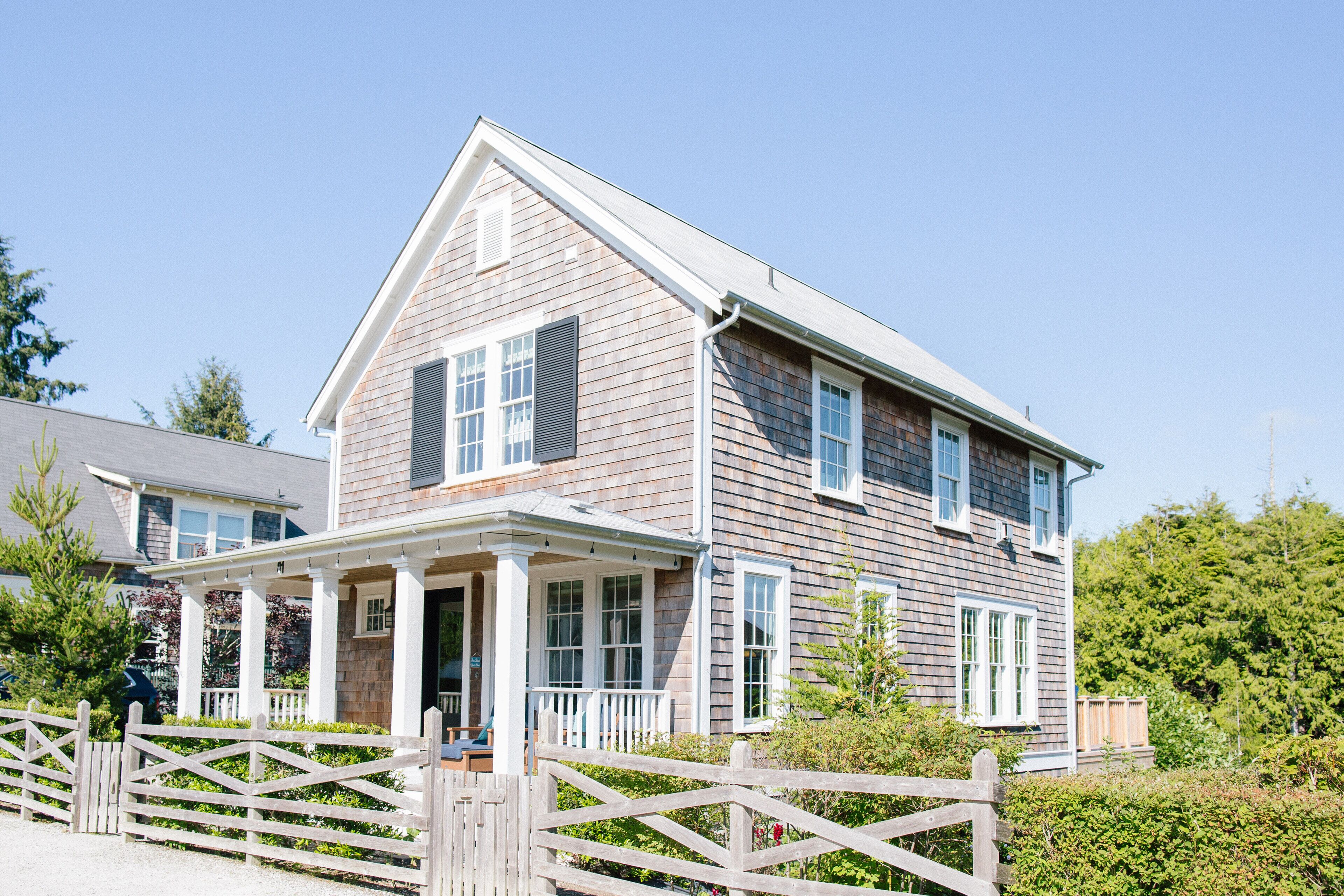 A two-story house with a porch, a garage, and a fenced yard.