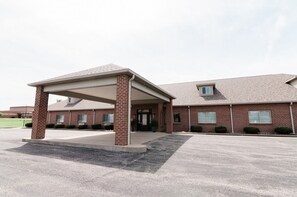 A brick building with a covered entrance and a small attached structure. - Conestoga Quarters (Jefferson City)