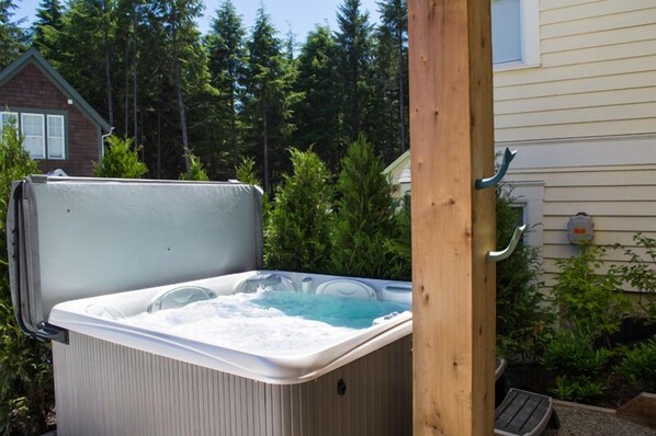 A hot tub in a backyard with a wooden post and a house in the background. - Seabrook Hannah's Haven | Hot Tub, Family, 3BR | Sleeps 8, Gnome Trail, Mill Dis (Pacific Beach)