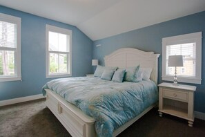A bedroom with a bed, nightstand, and window. - Seabrook Hannah's Haven | Hot Tub, Family, 3BR | Sleeps 8, Gnome Trail, Mill Dis (Pacific Beach)