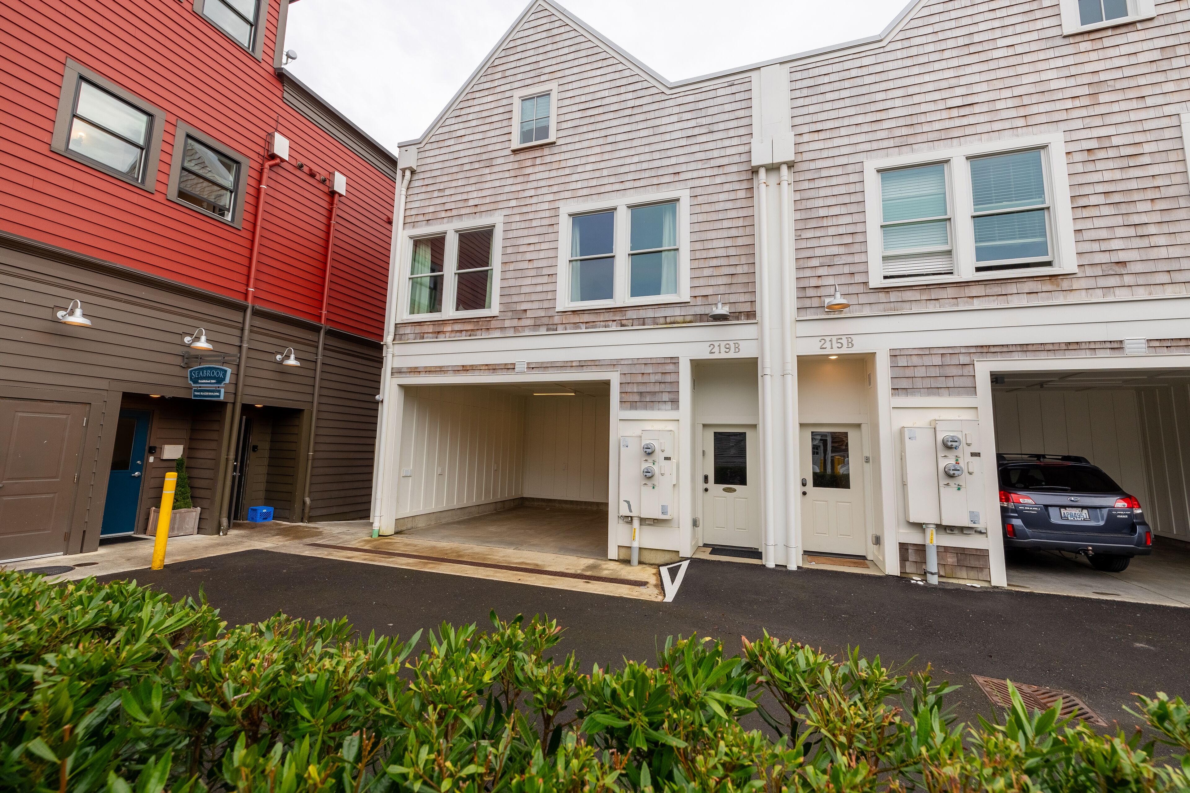 A building with two garages, one with a car parked inside.