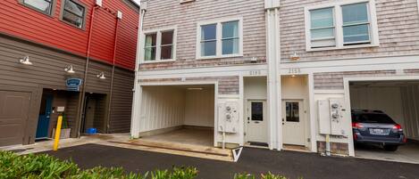 A building with two garages, one with a car parked inside.