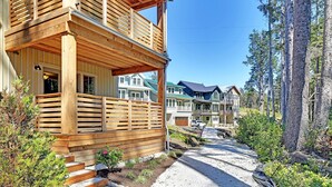 Une cabane en bois dotée d’un balcon, entourée d’une forêt.