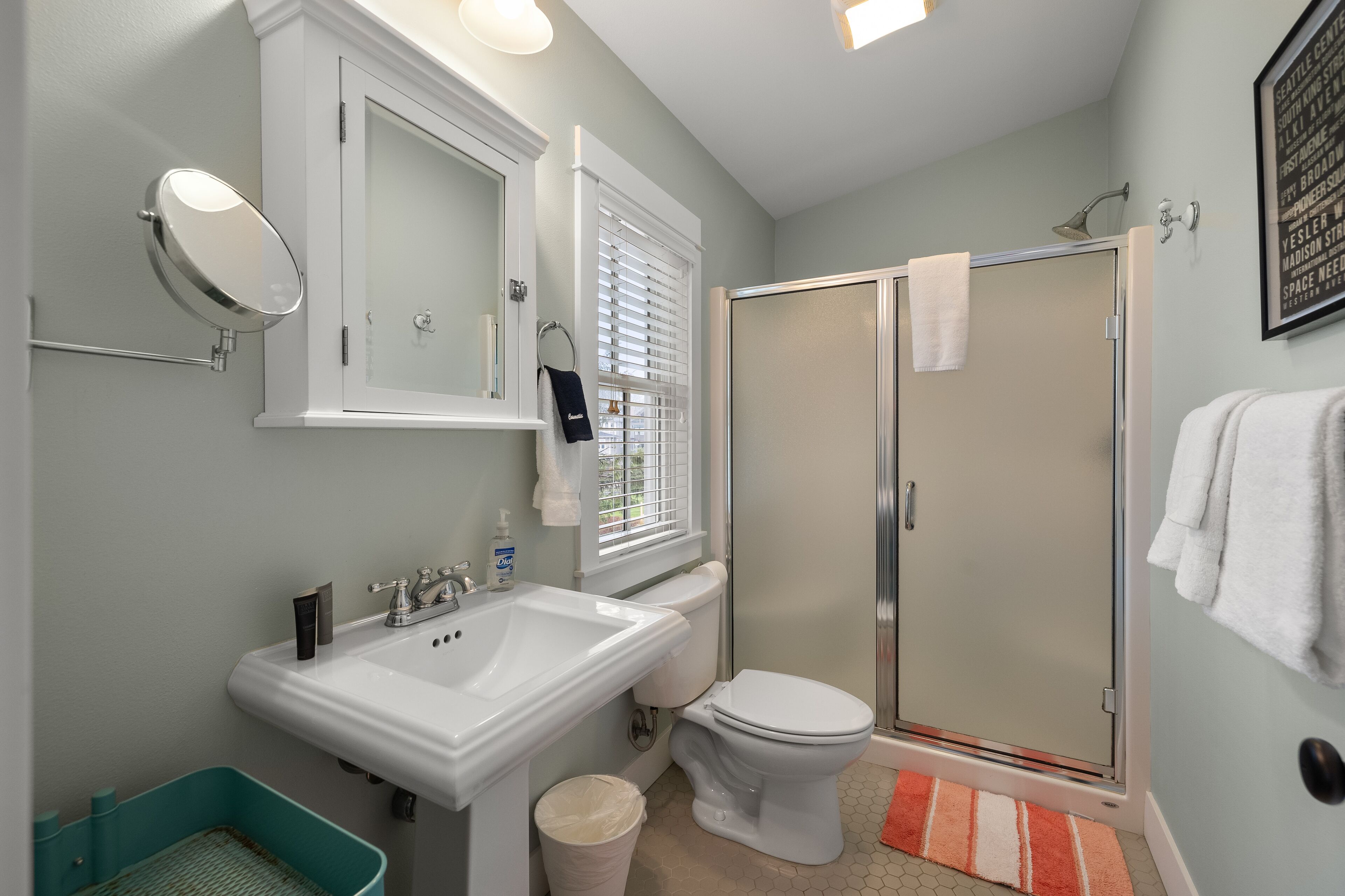 Une salle de bain avec un lavabo blanc, des toilettes et une douche à parois de verre.