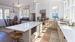Una cocina amplia con armarios blancos, una isla grande y una zona de comedor con banco.