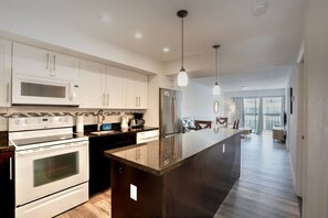A modern kitchen with white cabinetry, stainless steel appliances, and a central island. - 2 bedroom apt near beach w/pool (Sunny Isles Beach)