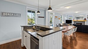 Una cocina moderna con encimera de granito, pileta de acero inoxidable e iluminación colgante.