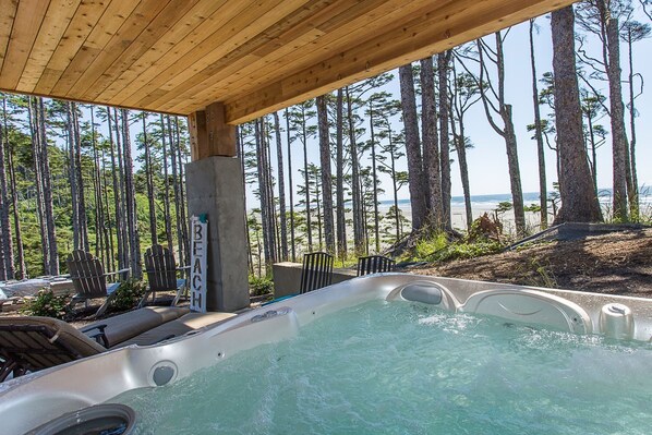 Un bain à remous doté d’un plafond en bois, entouré de chaises et d’un panneau indiquant « BEAC ».