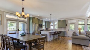 A spacious kitchen with a central island, wooden dining table, and chairs. - *NEW* Seabrook's On The Rocks: Hot Tub & Dog Friendly (Pacific Beach)