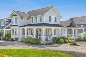 Une maison à deux étages avec un porche couvert, un garage et une allée.
