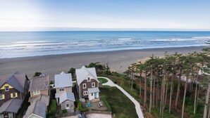 A coastal residential area with houses, a beach, and a clear sky. - Seabrook Sandy Side Up | Oceanfront, Hot Tub | 4BR, Sleeps 10, Seastack Views (Pacific Beach)
