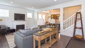 A living room with a fireplace, sofa, TV, and a wooden coffee table. - Seabrook's Seabiscuit: Dog Friendly, Hot Tub! (Pacific Beach)
