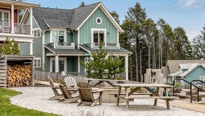 A two-story house with a porch, outdoor seating, and a gravel driveway. - Seabrook's Seaglass Cottage, close to the indoor pool! (Pacific Beach)
