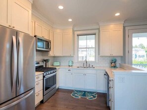 Enjoy cooking in this well-equipped kitchen with a large island, sink, and modern appliances.