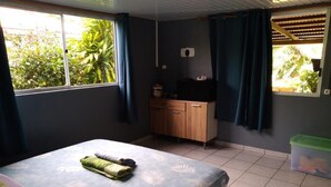 Une chambre à coucher avec un lit, une armoire en bois et une fenêtre avec des rideaux.