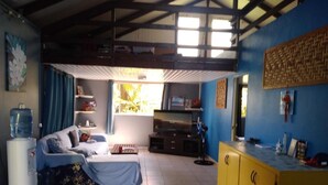 Une chambre avec un lit, un distributeur d’eau, une télévision et un comptoir jaune.