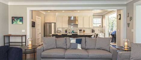 A modern living room with a grey sofa, a wooden coffee table, and a small side table with a lamp.