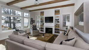 A living room with a fireplace, bookshelves, and a television.