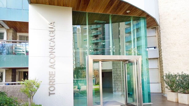 A modern building entrance with a glass door and a sign reading "TORRE ACONCAGUA". - Beautiful condo with Swimming Pool  and 24/7 security (Córdoba)