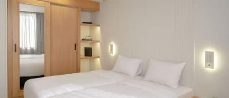 A bedroom with a large bed, wooden wardrobe, bedside tables, and wall-mounted lighting.