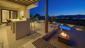 A modern outdoor patio with a fire feature, seating, and a view of the landscape. - Villa LADY with heated pool, jacuzzi and sauna (Pinezići)