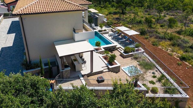 A modern villa with a swimming pool, outdoor seating, and a view of the sea. - Villa LADY with heated pool, jacuzzi and sauna (Pinezići)