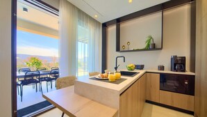 A modern kitchen with a breakfast bar, a coffee machine, and a view of the outdoors. - Villa LADY with heated pool, jacuzzi and sauna (Pinezići)