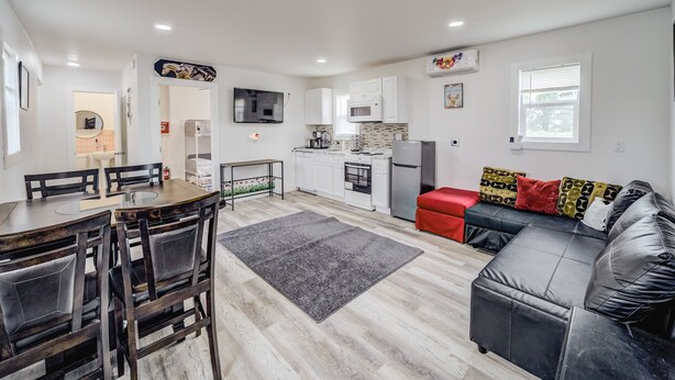 A modern apartment with a dining area, kitchen, and living room.
