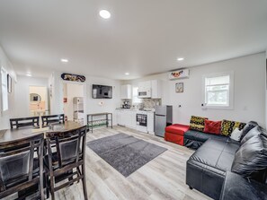 A modern apartment with a dining area, kitchen, and living room. - Cozy Tiny Homes Yellow (Rhome)
