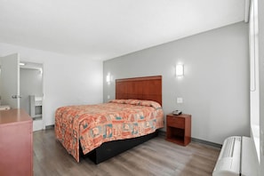 A bedroom with a bed, bedside table, and a wardrobe.